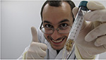 Student in laboratory holding sample